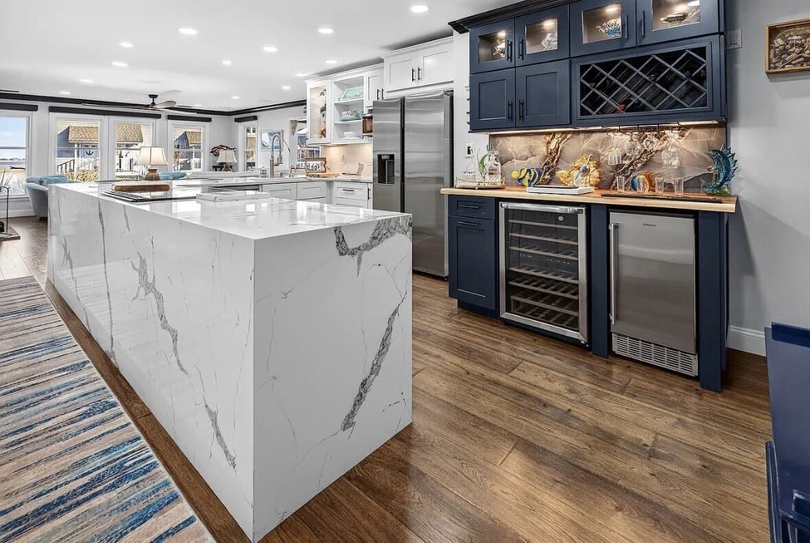 A custom kitchen with navy cabinetry and a built-in wine bar by Journey Construction